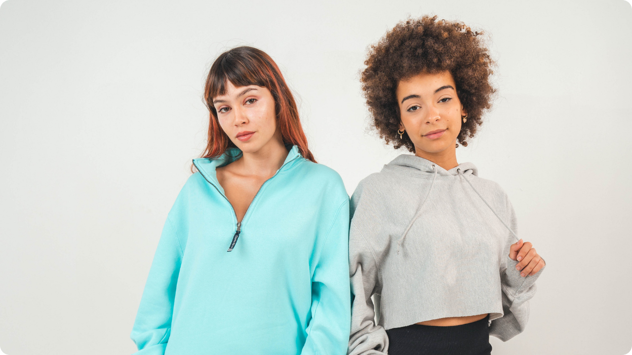 Photo of two women wearing a quarterzip jacket and a hoodie